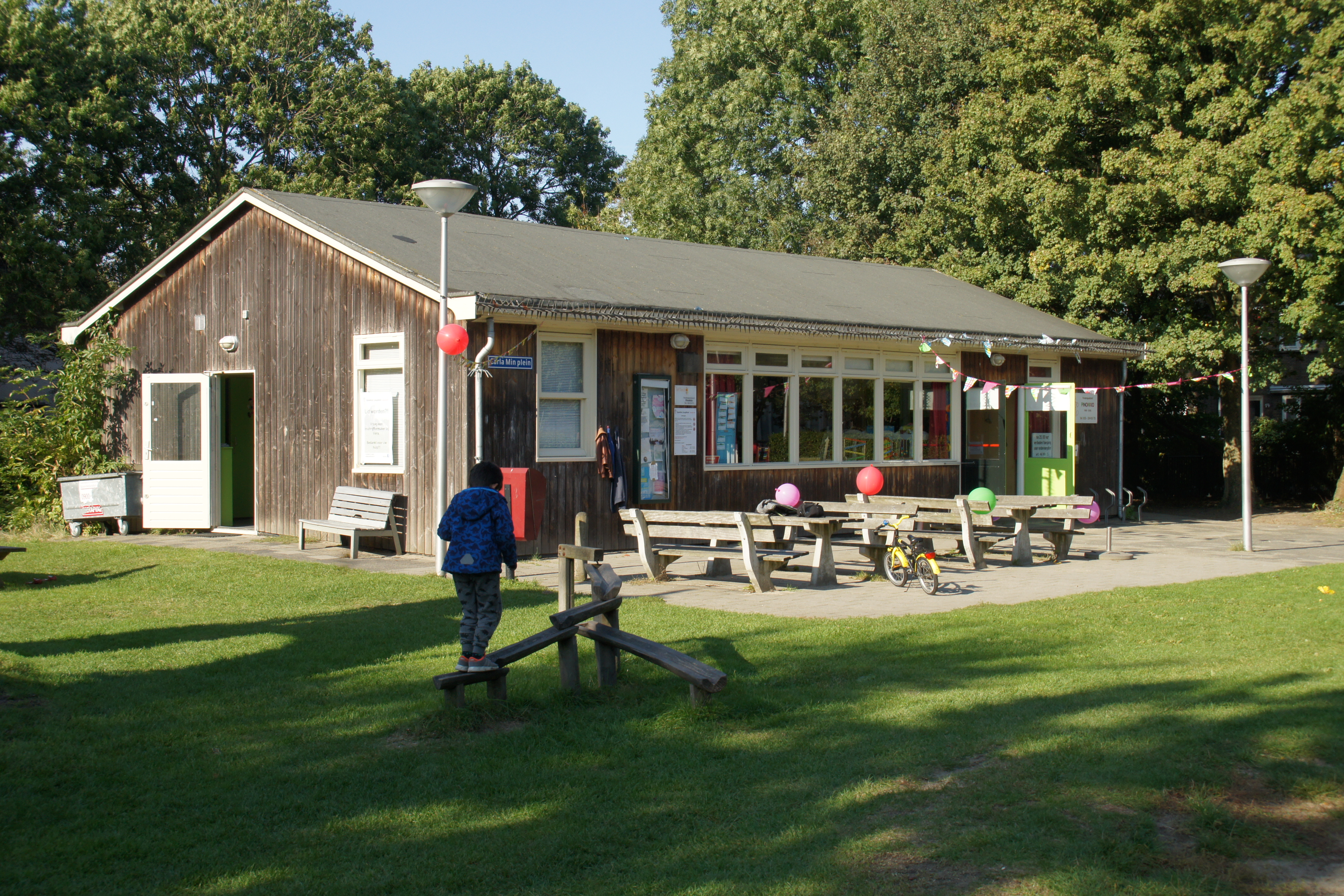 Het speeltuinhuisje met picknickbanken en tafels